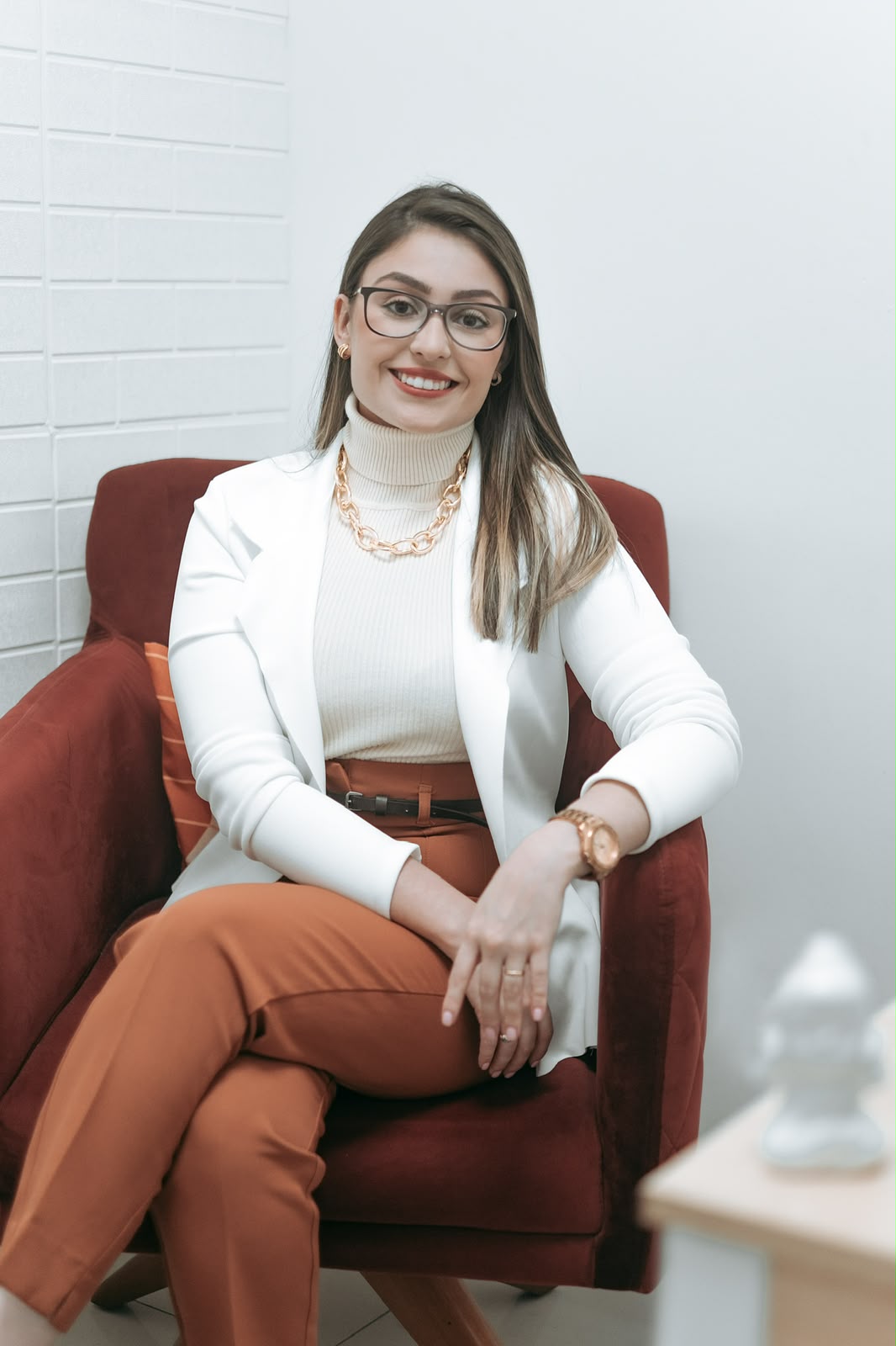 Isabelle Dias sentada em poltrona do consultório